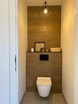 a toilet in a bathroom with a wooden wall at Vakantiewoning De Winning in Houthalen-Helchteren