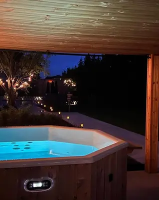 a jacuzzi tub in a backyard at night at Vakantiewoning De Winning in Houthalen-Helchteren