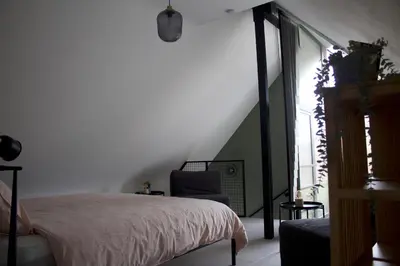 a bedroom with a bed and a chair at Aan Wal in Rekem