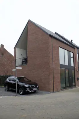 a black car parked in front of a brick building at Aan Wal in Rekem