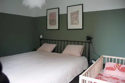 two beds in a room with green walls at Aan Wal in Rekem
