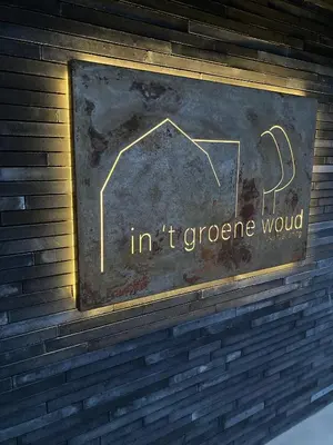 a sign on a brick wall that reads int crore wound at In't Groene Woud in Peer