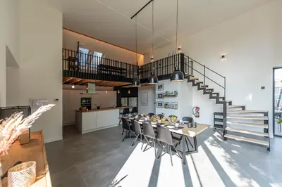 a dining room with a table and chairs and stairs at In't Groene Woud in Peer