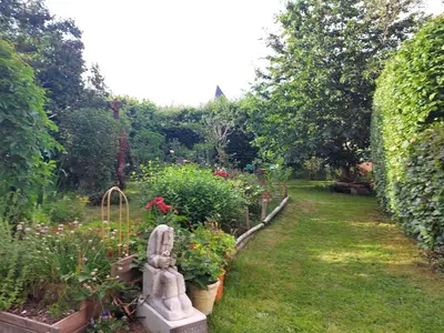 a garden with a statue and some plants at L'Atelier Bed and Breakfast in Andrimont