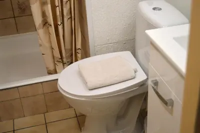 a bathroom with a toilet with a towel on the seat at Oasis Verte in La Calamine