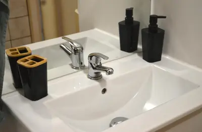 a bathroom sink with two soap dispensers on it at Oasis Verte in La Calamine