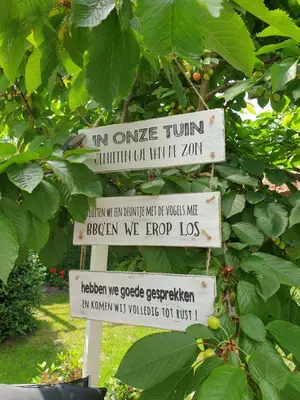 a sign in front of a tree with leaves at Tijd voor jezelf en elkaar bij Me&We in Zutendaal