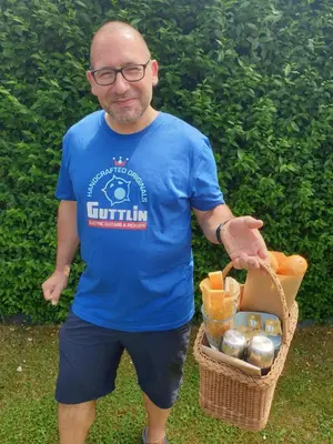 a man in a blue shirt holding a basket of food at Tijd voor jezelf en elkaar bij Me&We in Zutendaal