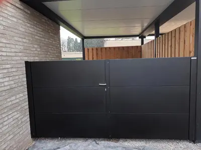 a black garage door in front of a brick wall at VERADEMING in Bilzen