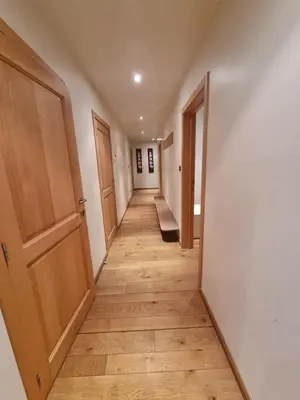 an empty hallway with wooden floors and doors at SusBerg-1 & 2 in Pelt
