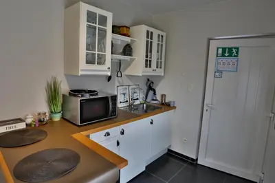 a kitchen with white cabinets and a sink and a microwave at Vakantiewoning Casa Maran in een groene omgeving te Heusden-Zolder in Heusden - Zolder