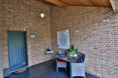 a brick wall with a table with a laptop on it at Vakantiewoning Casa Maran in een groene omgeving te Heusden-Zolder in Heusden - Zolder