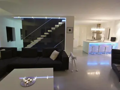 a living room with a black couch and a staircase at B&B Bianero in Peer