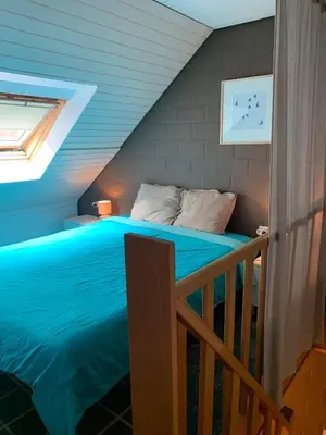 a bedroom with a blue bed in a attic at De Bosdreef - Hengelhoef - duplex met verwarmd openluchtzwembad in Houthalen-Helchteren