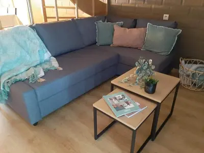 a blue couch in a living room with two tables at De Bosdreef - Hengelhoef - duplex met verwarmd openluchtzwembad in Houthalen-Helchteren
