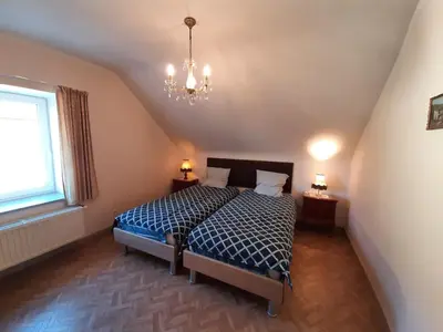a bedroom with a bed and a chandelier at Aan het Singelhof - Bellefleur*** met sunshower en tuin in Sint-Truiden