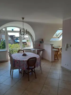 a dining room with a table and chairs and a kitchen at Aan het Singelhof - Bellefleur*** met sunshower en tuin in Sint-Truiden
