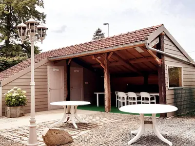 two tables and chairs in front of a shed at Aan het Singelhof - Bellefleur*** met sunshower en tuin in Sint-Truiden
