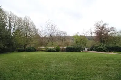 a large grassy field with trees and bushes at Oscappart in Eupen