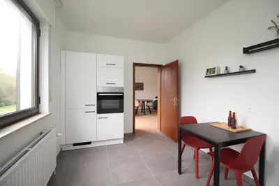 a kitchen and dining room with a table and chairs at Oscappart in Eupen