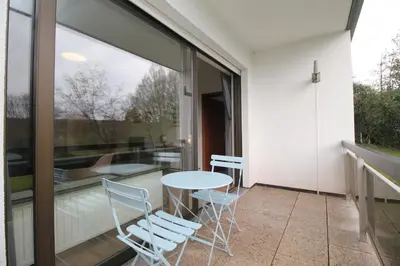 a glass balcony with a table and chairs at Oscappart in Eupen