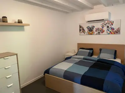 a bedroom with a bed and a dresser at Guest House en famille ou en couple à la campagne in Romsée