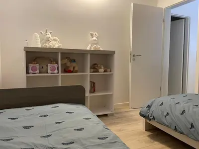 a bedroom with a bed and a shelf with stuffed animals at Guest House en famille ou en couple à la campagne in Romsée