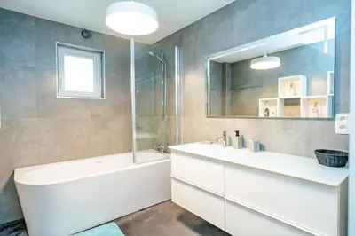 a bathroom with a tub and a sink and a mirror at Guest House en famille ou en couple à la campagne in Romsée