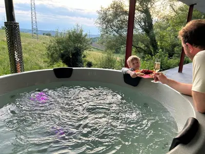 a man and a child in a jacuzzi tub at Guest House en famille ou en couple à la campagne in Romsée