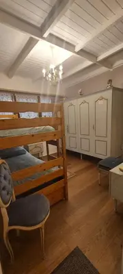 a room with three bunk beds and a chandelier at 'T boshuisje in Oudsbergen