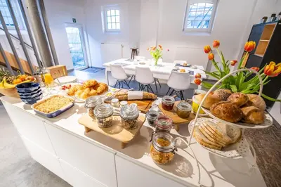 a breakfast buffet with bread and pastries on a table at Ô Macra B&B - Aubel, Pays de Herve in Aubel