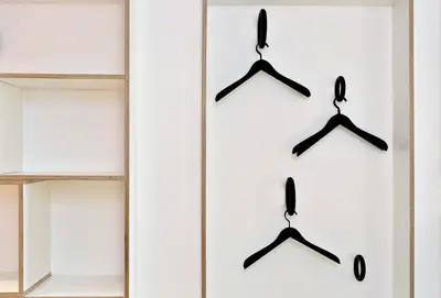 a closet with black hangers on a white wall at Ô Macra B&B - Aubel, Pays de Herve in Aubel