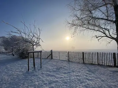 a table in the snow next to a fence at Ô Macra B&B - Aubel, Pays de Herve in Aubel