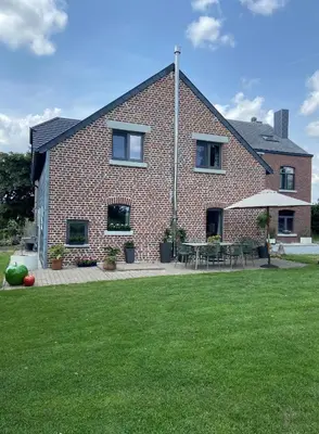 a brick house with a lawn in front of it at Ô Macra House - Aubel, Pays de Herve in Aubel