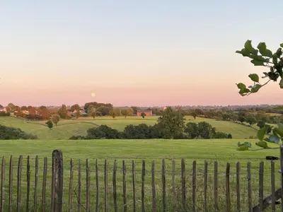 a fence in a field with the sunset in the background at Ô Macra House - Aubel, Pays de Herve in Aubel