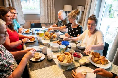 a group of people sitting around a table eating food at Ô Macra House - Aubel, Pays de Herve in Aubel