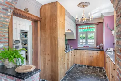 a kitchen with purple walls and a window at Huize Koedoe in Tongeren