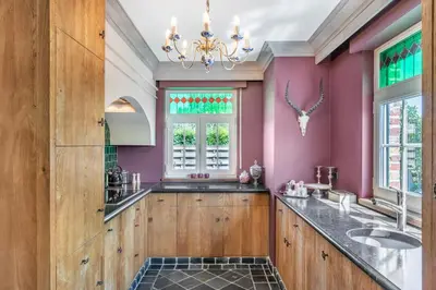 a bathroom with purple walls and a sink and a chandelier at Huize Koedoe in Tongeren