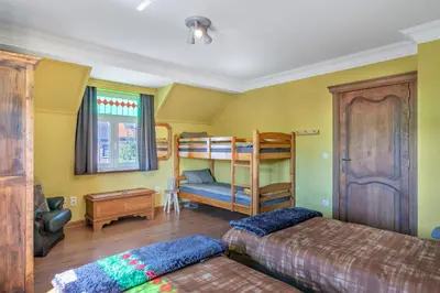 a bedroom with two bunk beds and a couch at Huize Koedoe in Tongeren