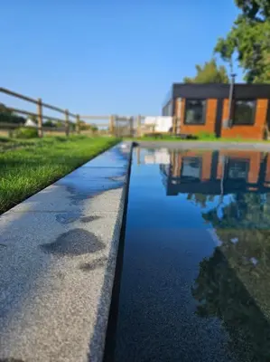 a canal of water with a house in the background at Houten huisje tussen paarden in Nieuwerkerken