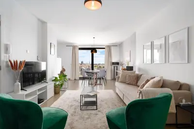 a living room with a couch and a tv at Saint Pablo Design Apt I 2BR, Free Parking, Stunning View & Large Terrace in Hasselt
