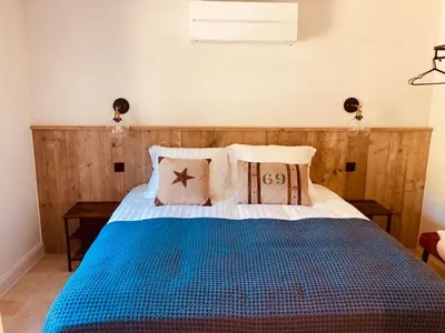a bedroom with a blue bed with two pillows at De Molenhoeve B&B in Voeren