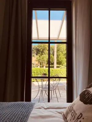 a bedroom with a bed and a window with a table at De Molenhoeve B&B in Voeren