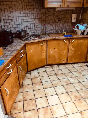 a kitchen with wooden cabinets and a tiled floor at Bien-être-Au-calme et parking gratuit in Seraing