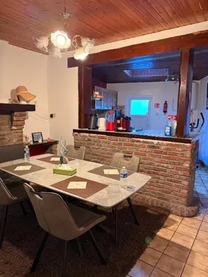 a dining room with a table and a brick wall at Bien-être-Au-calme et parking gratuit in Seraing