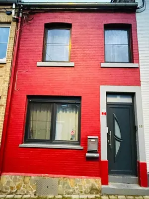a red house with a black door and windows at Bien-être-Au-calme et parking gratuit in Seraing