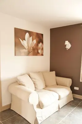 a white couch in a room with a painting on the wall at B&B De Fruithoeve in Hoeselt