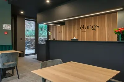 a restaurant with tables and chairs and a sign that reads clams at Aux Etangs - Hôtel in Battice