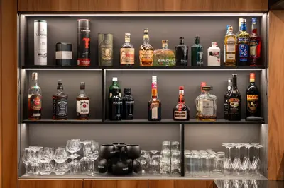a shelf filled with lots of bottles and glasses at Aux Etangs - Hôtel in Battice