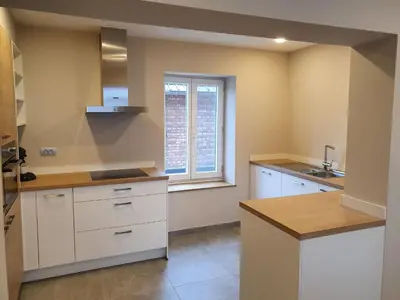 a kitchen with white cabinets and a window at De oude es in Bocholt